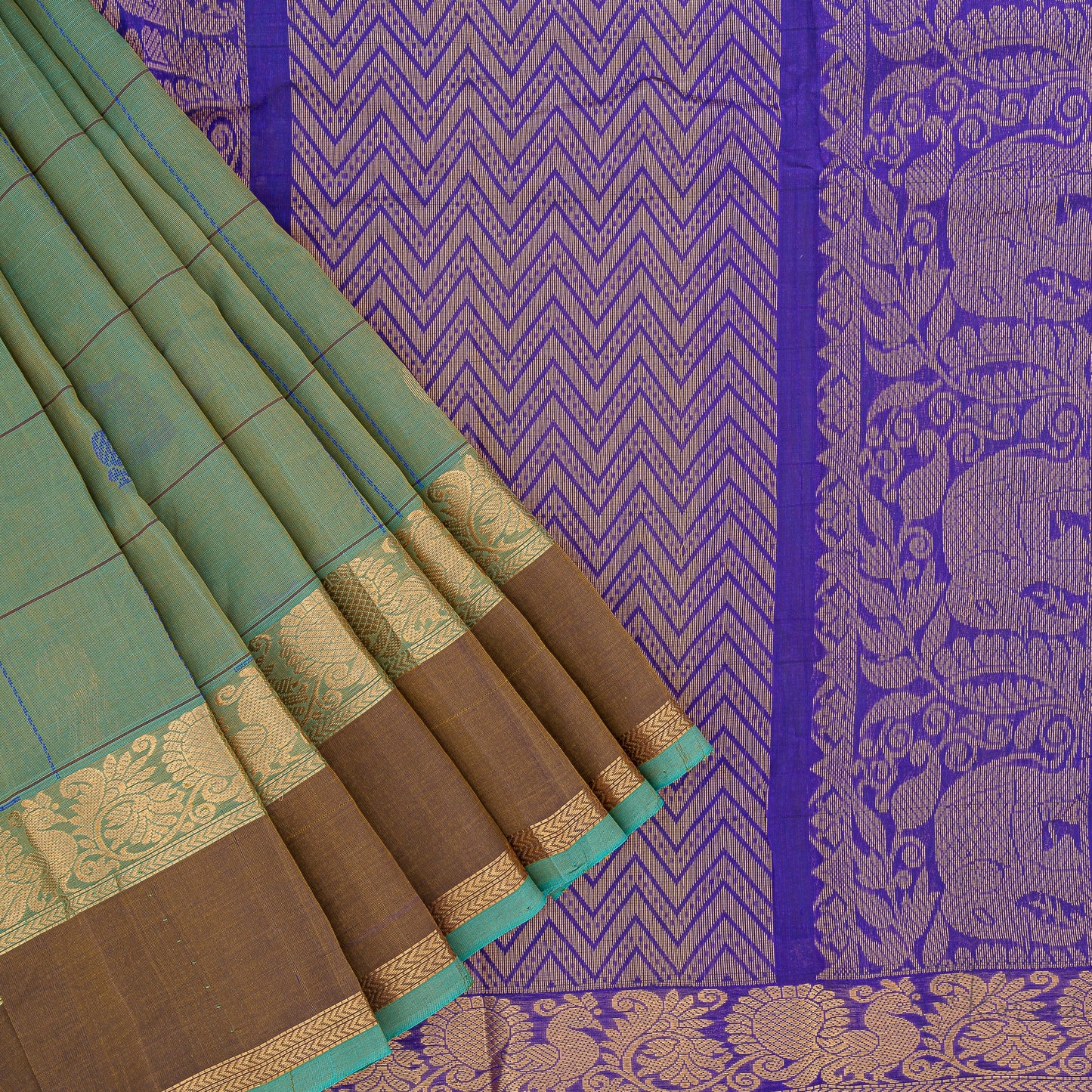 Green and cream shot coloured soft silk saree with closer view of dark blue pallu with intricate elephant motifs in gold.