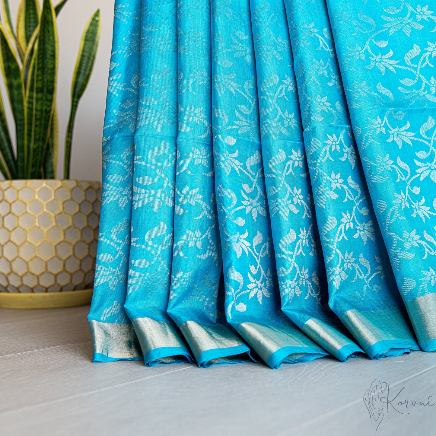 Pleated view of copper sulphate blue Kanjivaram soft silk saree with silver vine motifs.