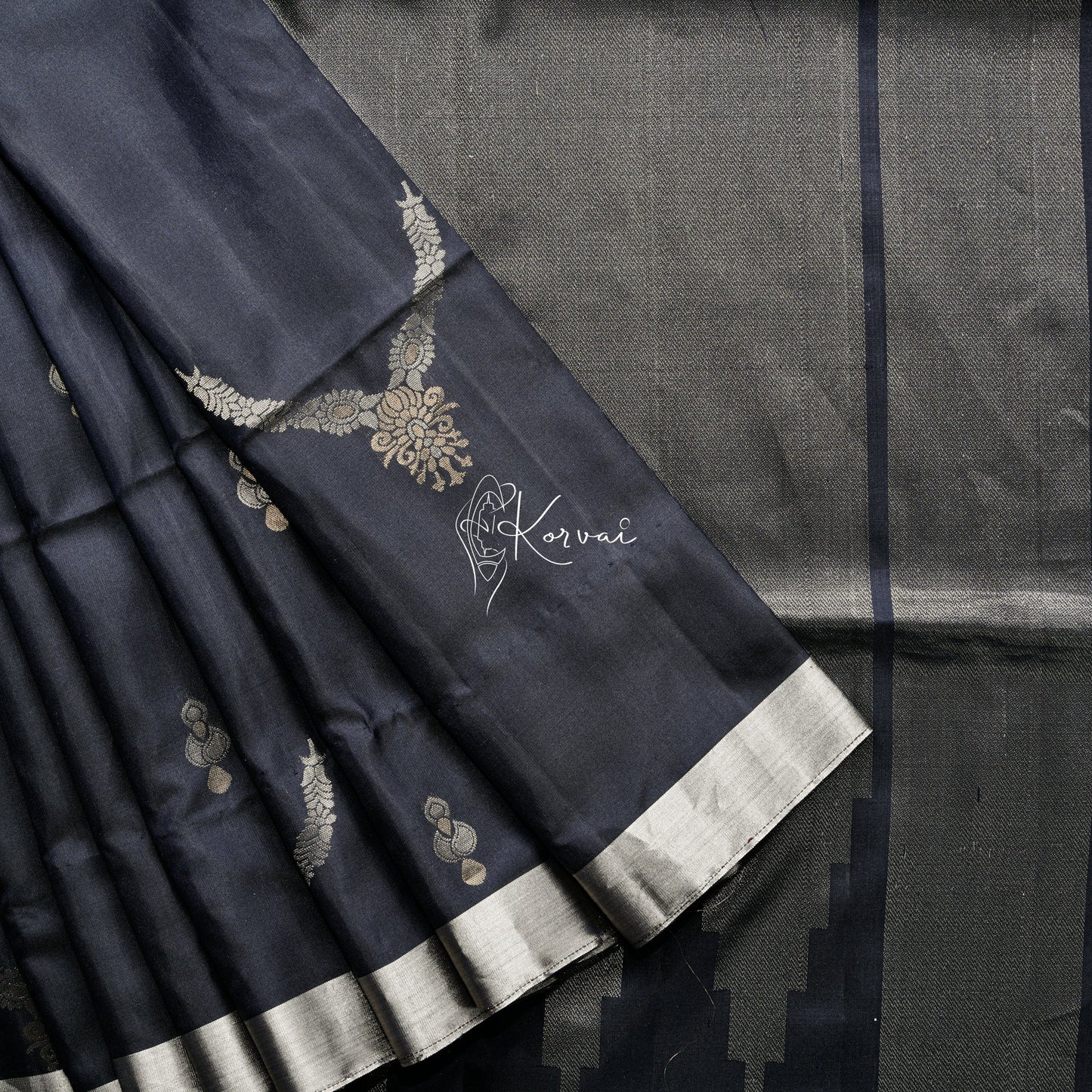 Black soft silk saree with necklace and wheel motifs in the body and intricate zari work in the pallu.