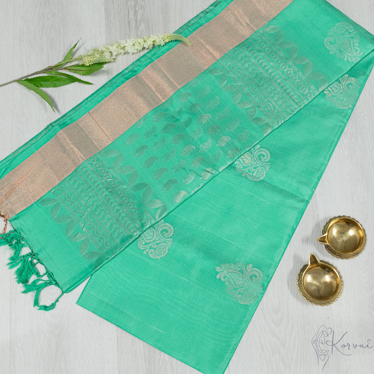Pastel green Kanjivaram soft silk saree with copper zari border.