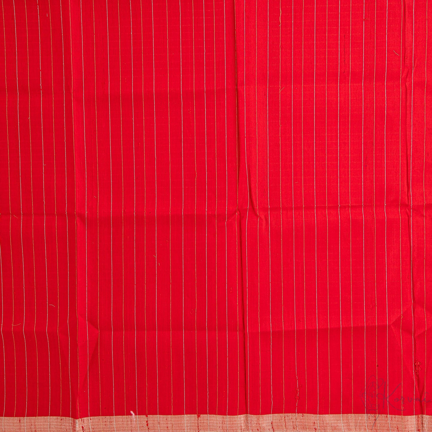 Closer view of the red blouse fabric with thin gold and silver stripes.