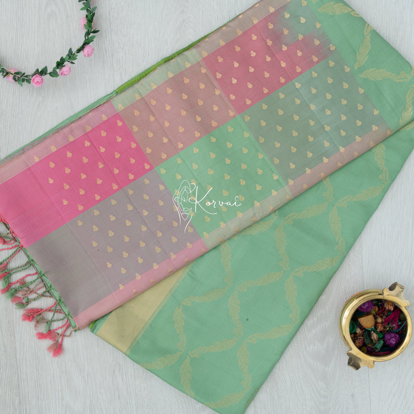 Top view of pastel green coloured Kanjivaram soft silk saree with shades of pink on the pallu.