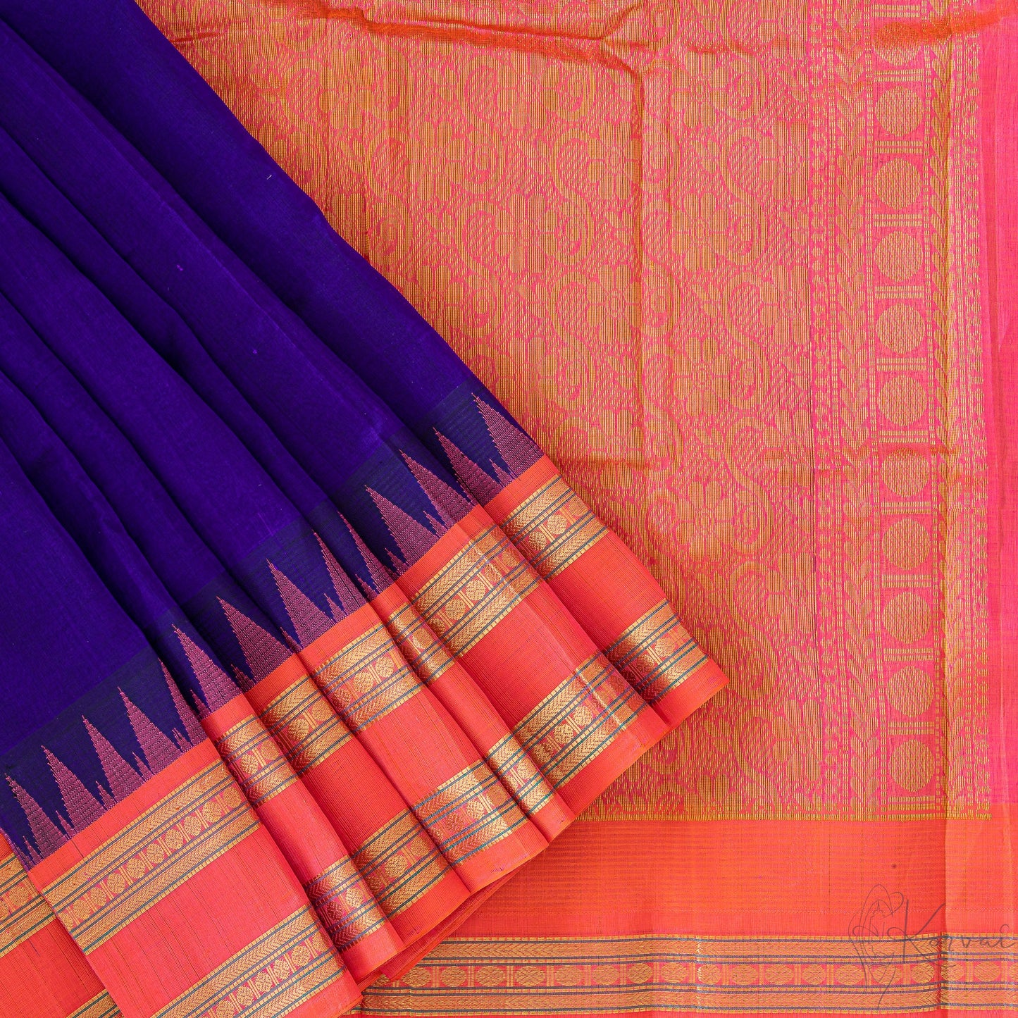 Blue silk cotton saree with orange border and orange temple korvai motifs.