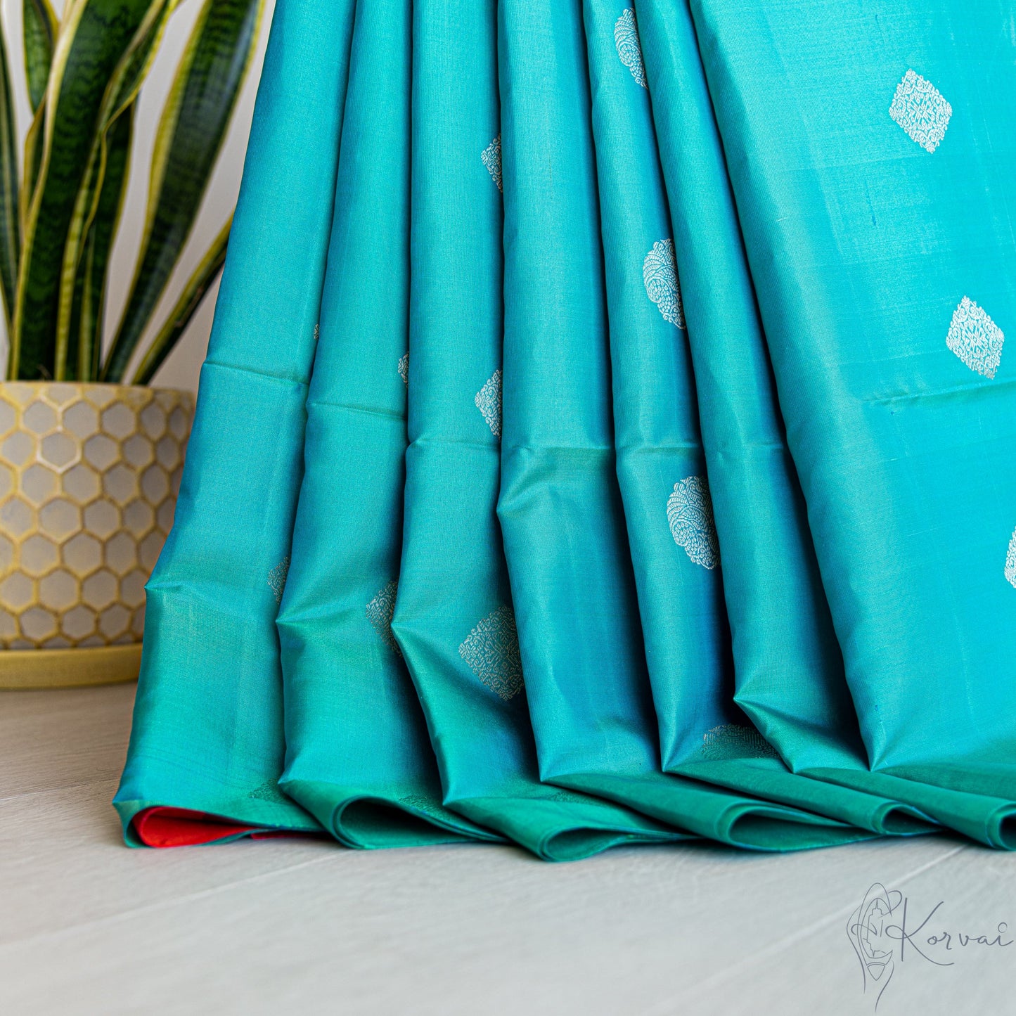 Pleated view of teal Kanjivaram soft silk saree.