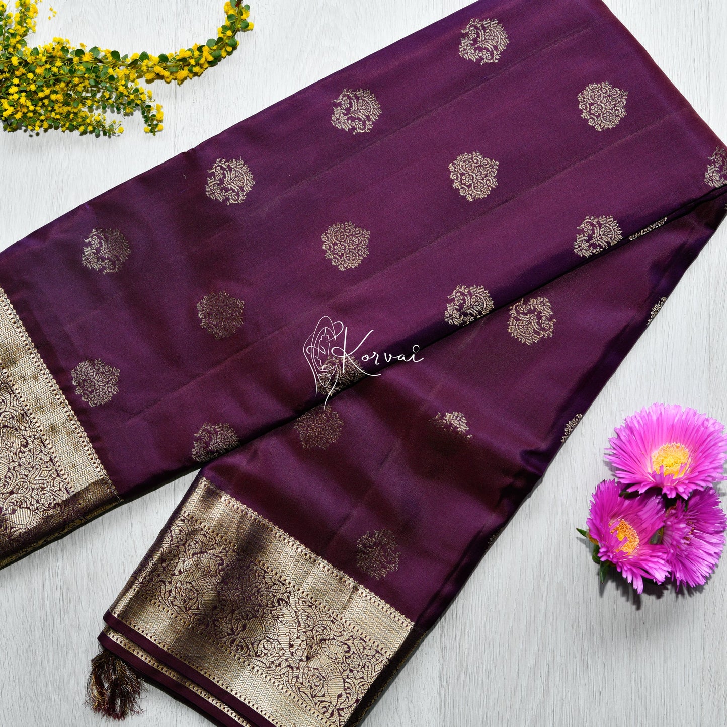 Top view of burgandy coloured soft silk saree with zari border in gold featuring Yali motifs.