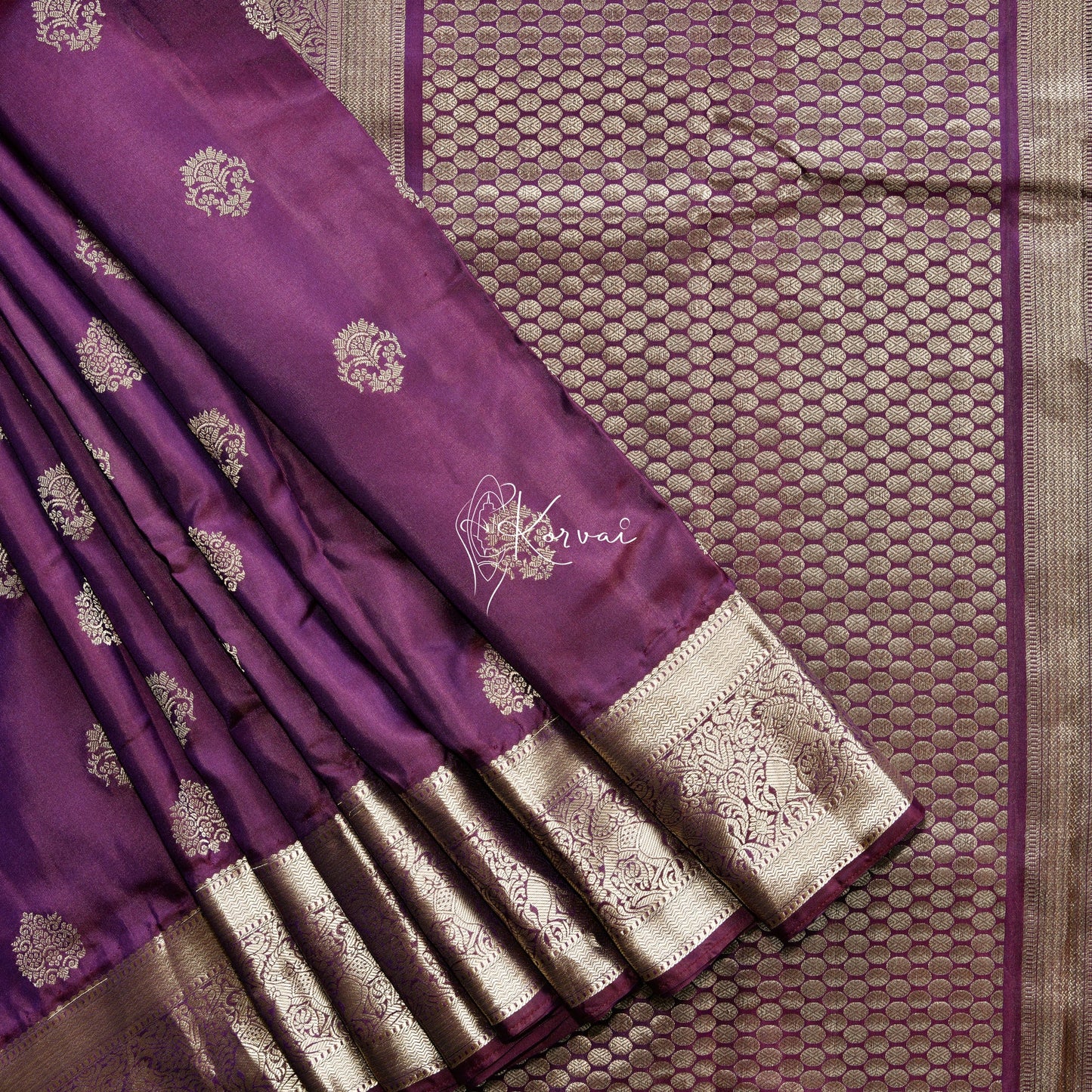 Burgandy coloured soft silk saree with flower motifs in the body and horse motifs in the pallu.