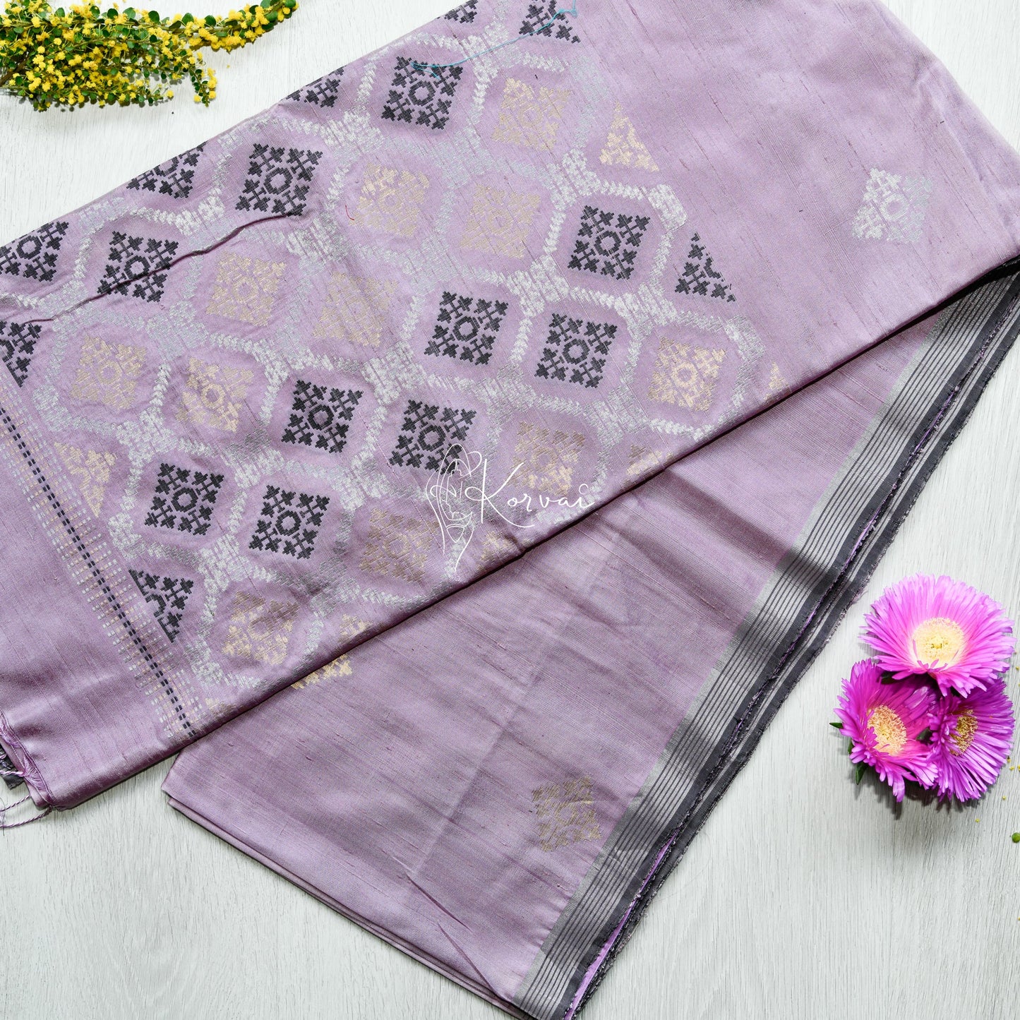 Top view of lilac soft silk saree with geometric motifs.