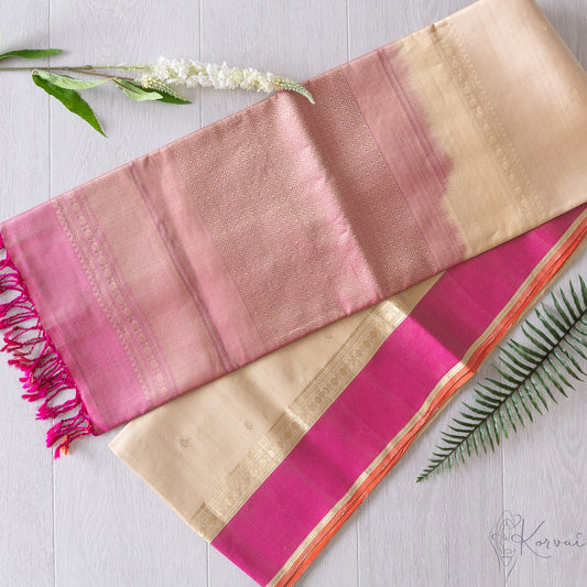 Cream Kanjivaram soft silk saree with baby pink border folded in half and baby pink pallu facing the top.