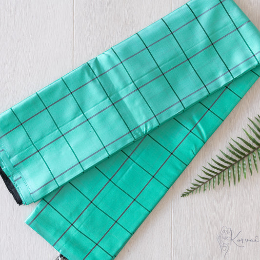 Teal Kanjivaram soft silk saree with black large checks and the saree folded in half.