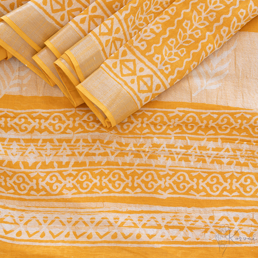 Top view of yellow cotton saree with white block prints all over.