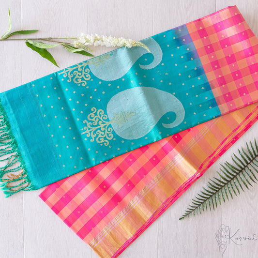 Pink and cream checkered Kanjivaram soft silk saree with teal pallu that has silver and gold Paisley design.