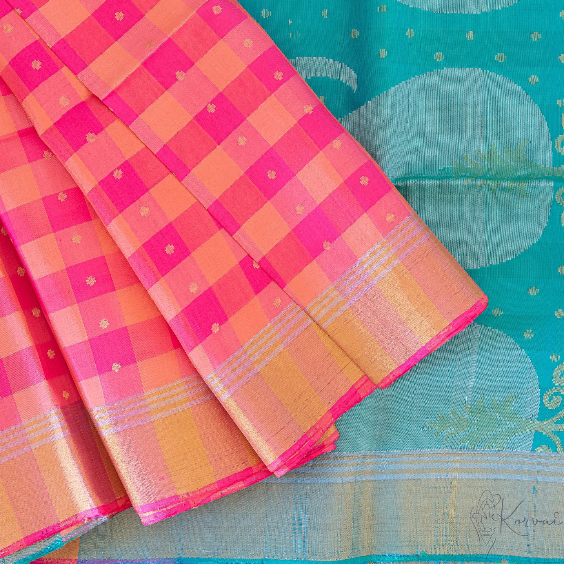 Top view of pink and cream checkered Kanjivaram soft silk saree with teal pallu.