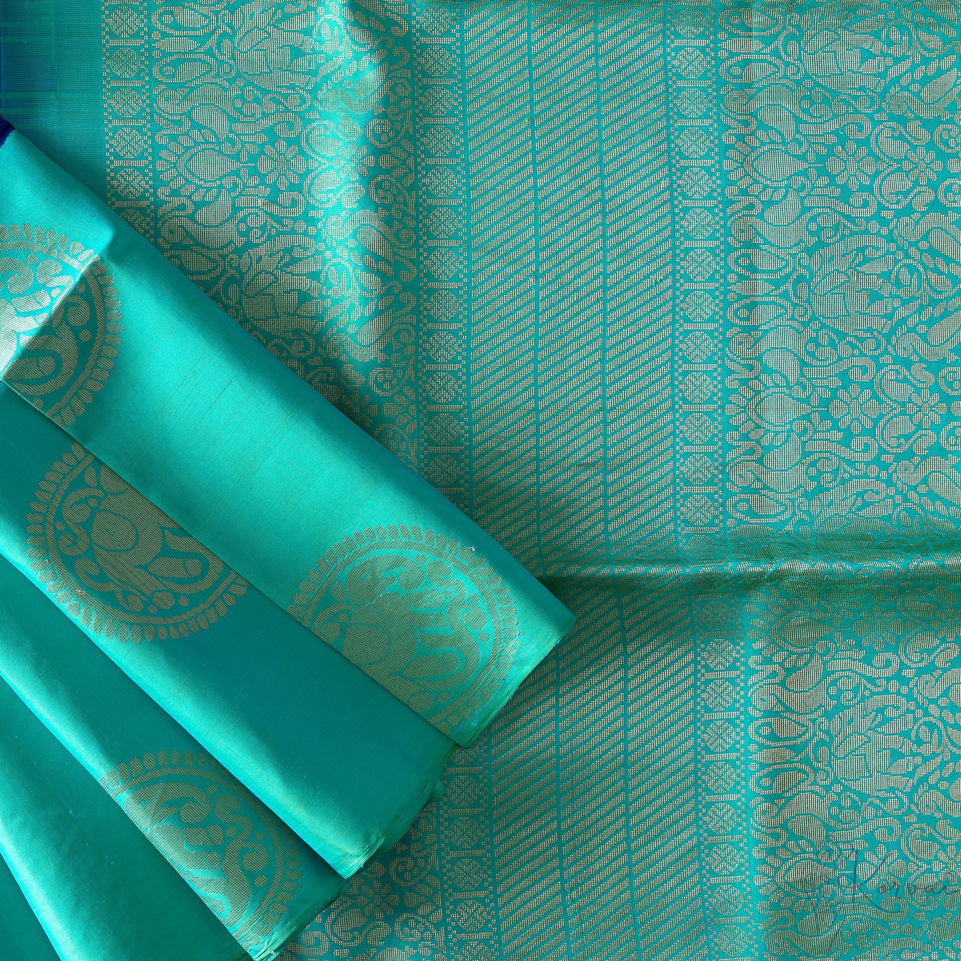 Top view of royal blue korvai Kanjivaram soft silk saree showing the teal pallu with intricate gold zari work.