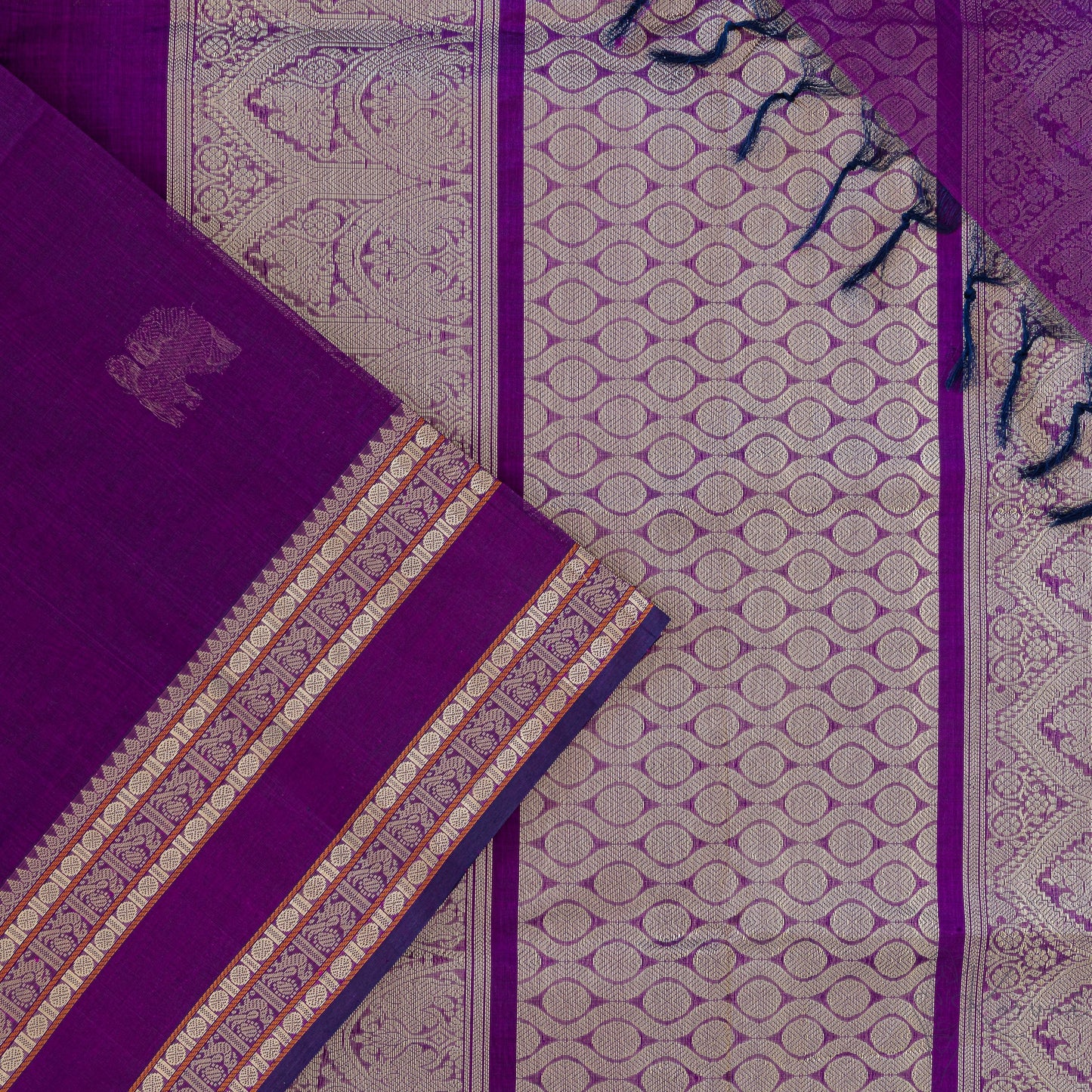 Violet silk cotton saree with closer view of violet pallu that has intricate gold zari work.