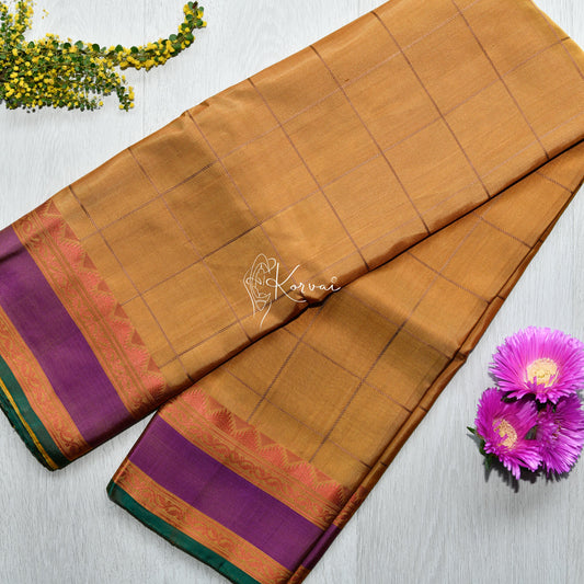 Top view of amber coloured soft silk saree with double border in violet featuring thalampoo motifs.