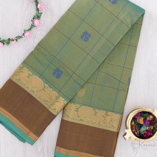 Green and cream shot coloured silk cotton saree with dark blue and brown checks and Annam motifs.