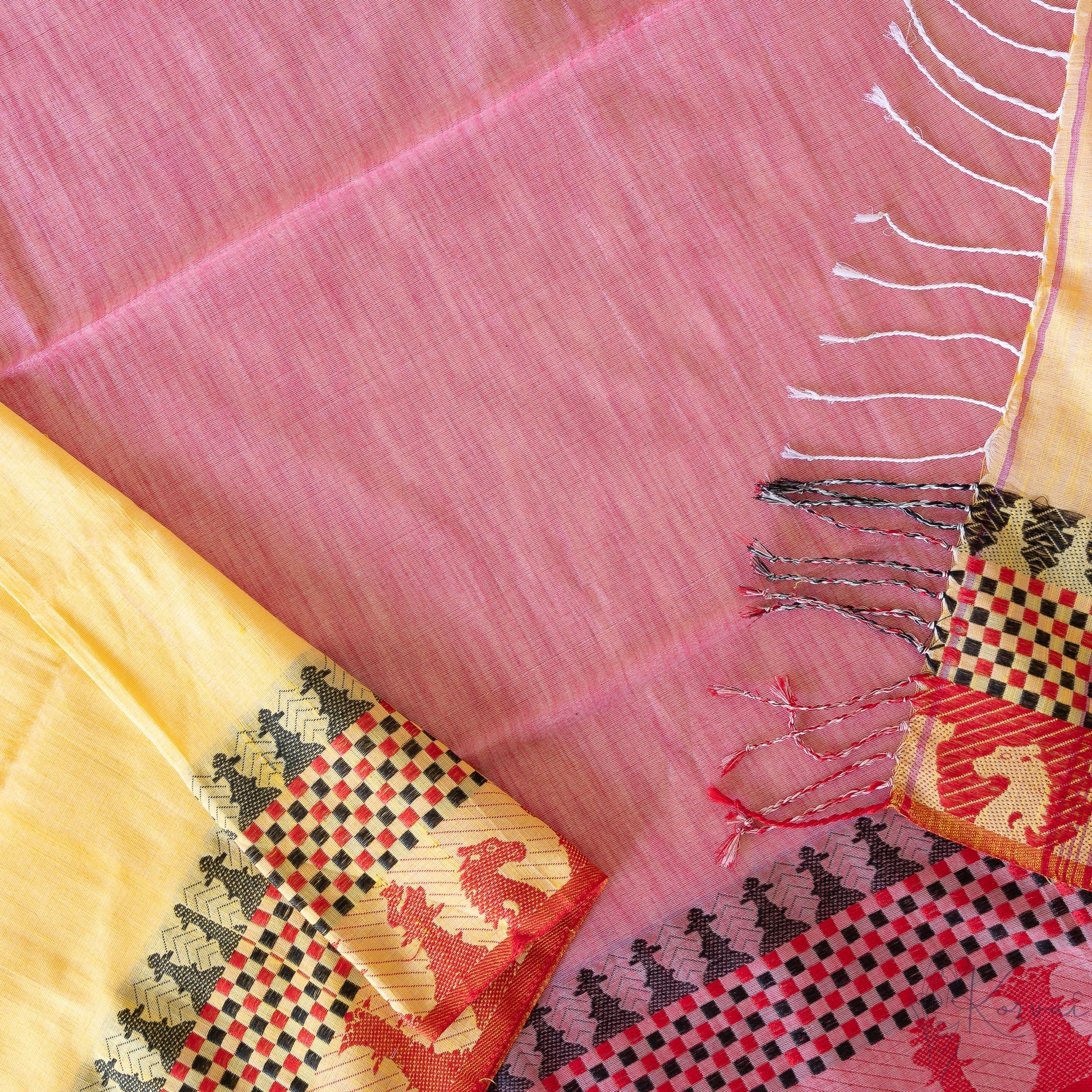 Top view of yellow kadhi cotton saree showing the pallu that is pink in colour and has chess board motifs with its coins in the border.