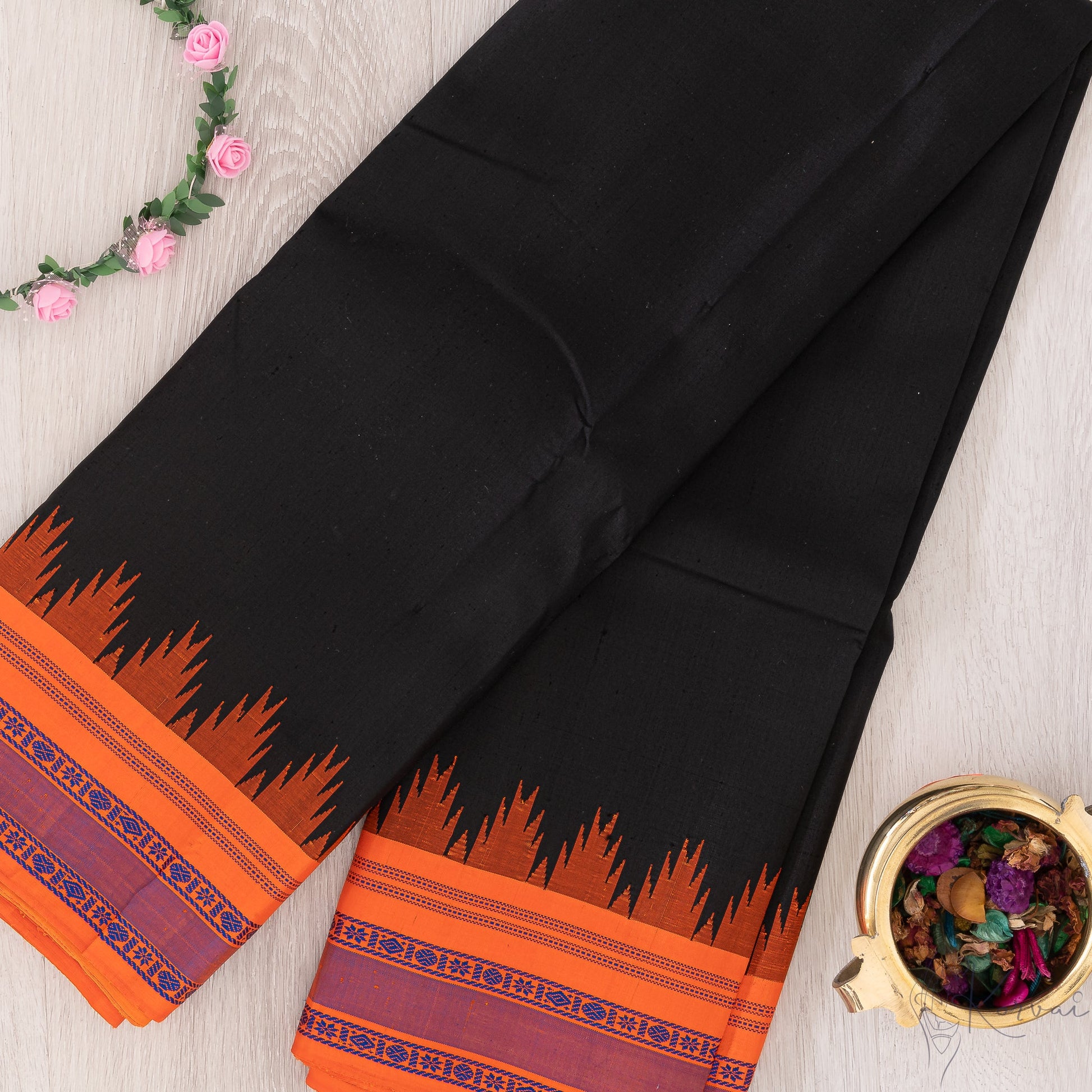 Plain black Kanjivaram silk saree with fanta orange temple korvai border.