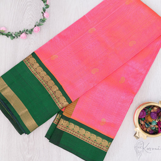 Pink silk cotton saree with bottle green border and mango motifs.