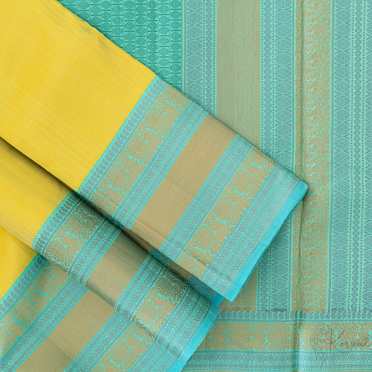 Lemon yellow Kanjivaram soft silk saree with teal double border and teal pallu.