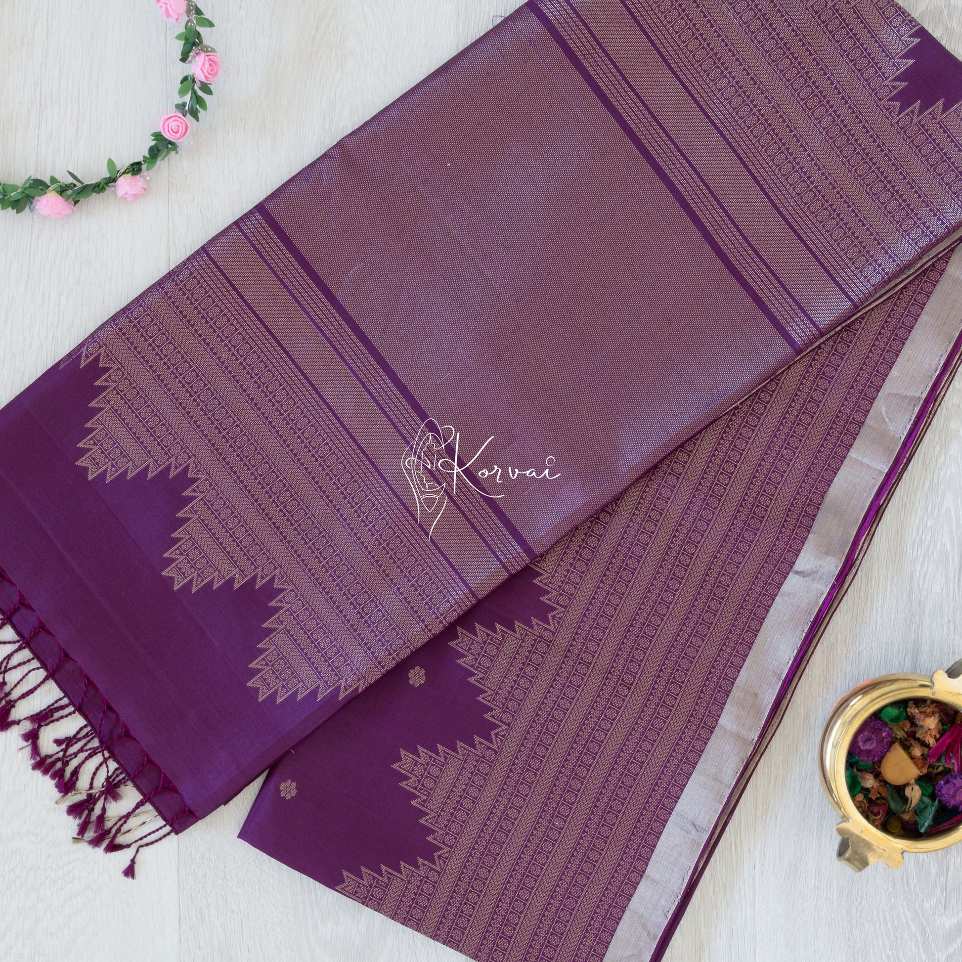 Top view of dark purple coloured Kanjivaram soft silk saree with temple motifs in gold zari on the pallu.