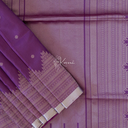 Dark purple coloured soft silk saree with tiny flower motifs in the body and temple motifs on the pallu.