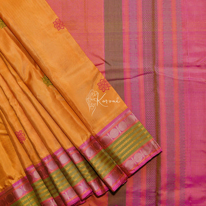 Yellow soft silk saree with pink and green flower motifs with intricate thread work in the pallu.