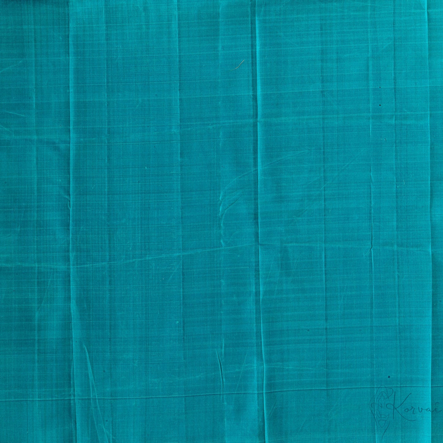 Closer view of teal plain blouse fabric.