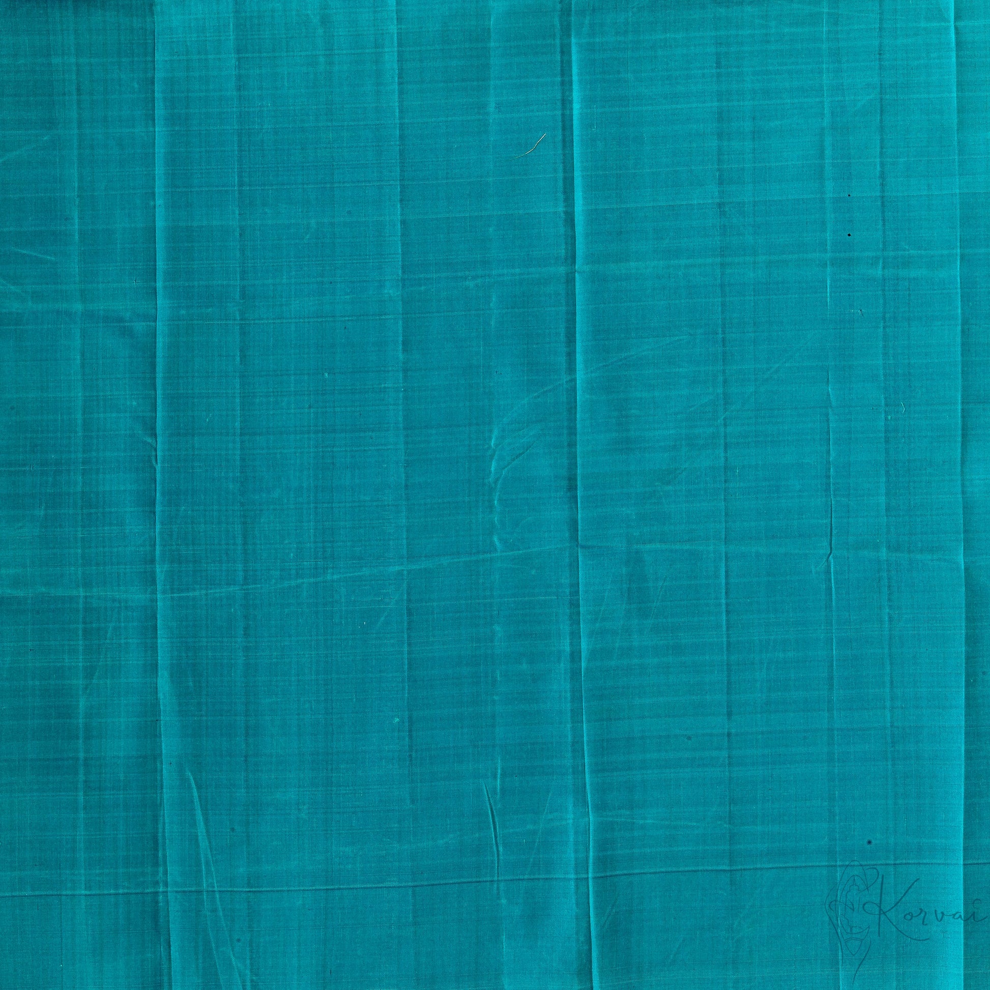 Closer view of teal plain blouse fabric.