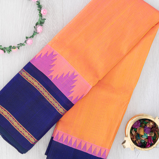 Orange silk cotton saree with pink korvai temple motifs in border and dark blue pallu.