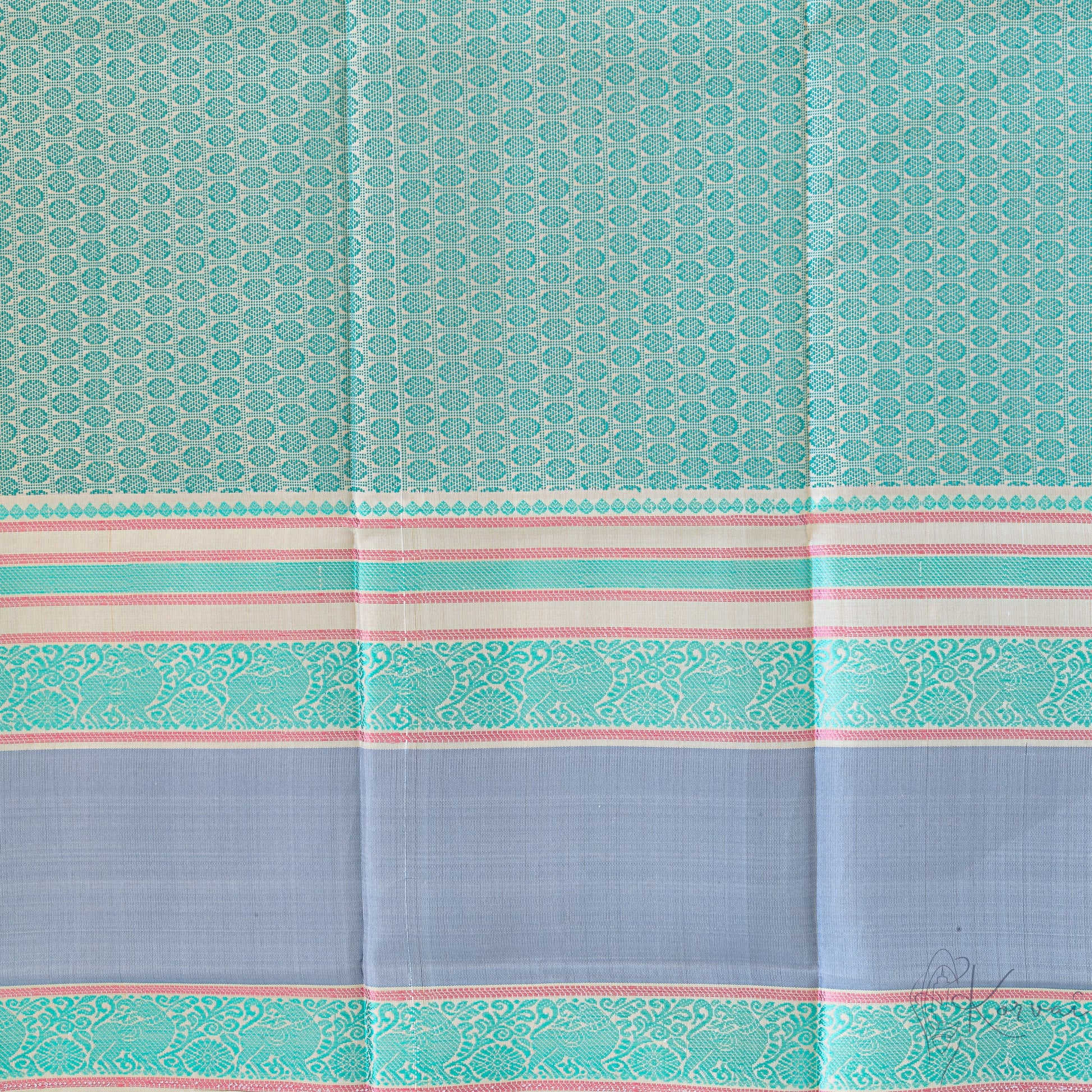 Closer view of the blouse fabric with teal double border and green jaquard design.