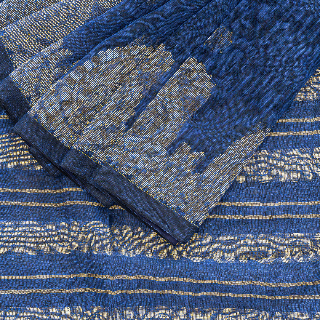 Blue linen saree with cream coloured paisley motifs.