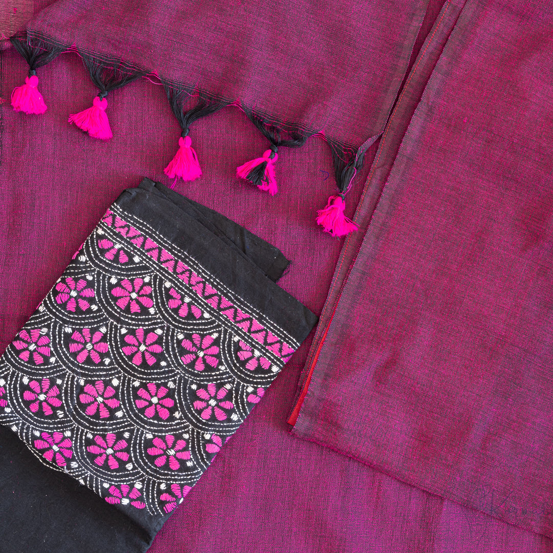 Top view of magenta coloured mul cotton saree with hot pink tassles on the edge of pallu with white and pink kanta stitched black blouse fabric.