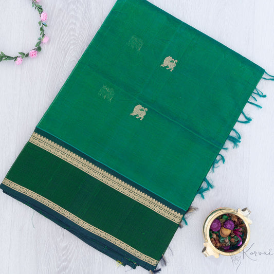 Bottle green silk cotton saree with double border and yaali motifs.