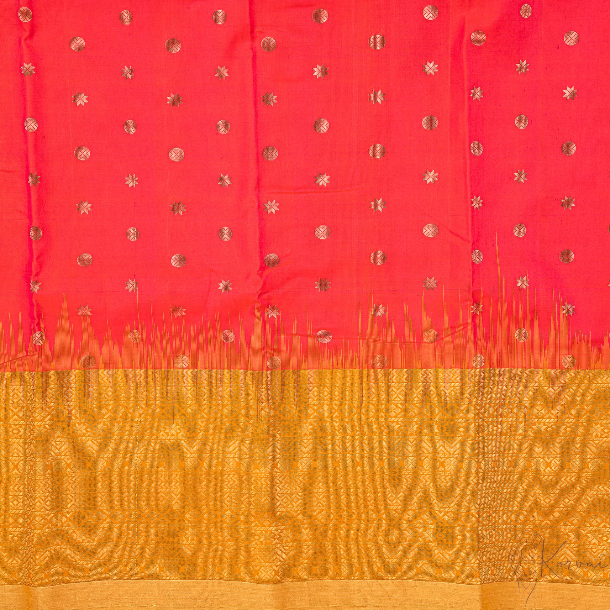 Closer view of pinkish red body with circle and star motifs and mustard pallu.